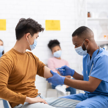 medical professional administering shot to a patient