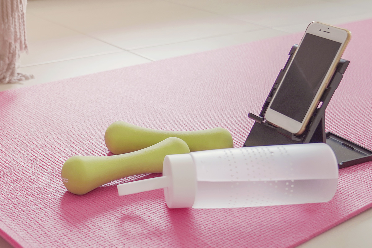 small weights, bottled water, yoga mat and a cell phone