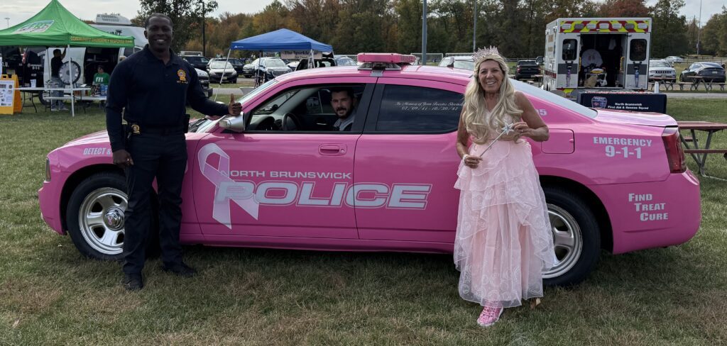 DPRCS Director Lou Ann Benson and NBTPD officers pose with PD pink car
